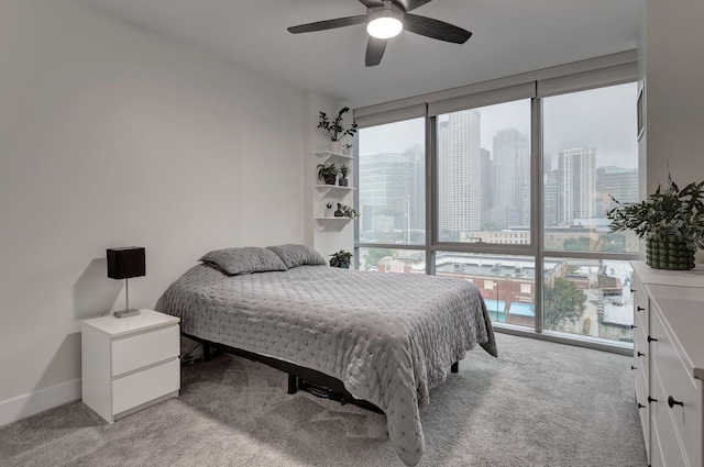 bedroom featuring a view of city, multiple windows, and light carpet