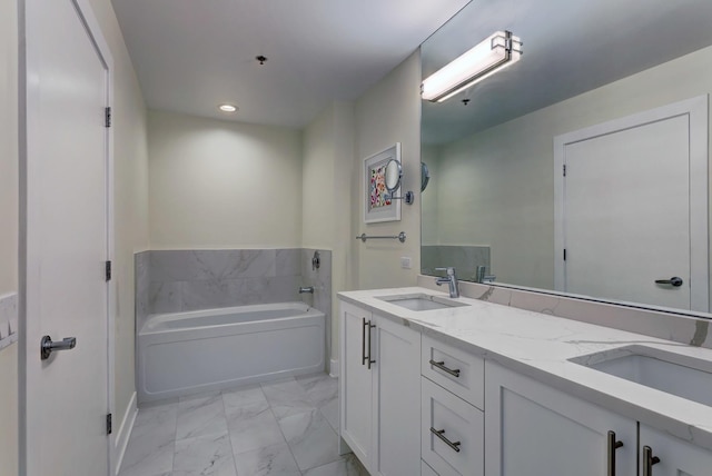 bathroom featuring double vanity, marble finish floor, a garden tub, and a sink