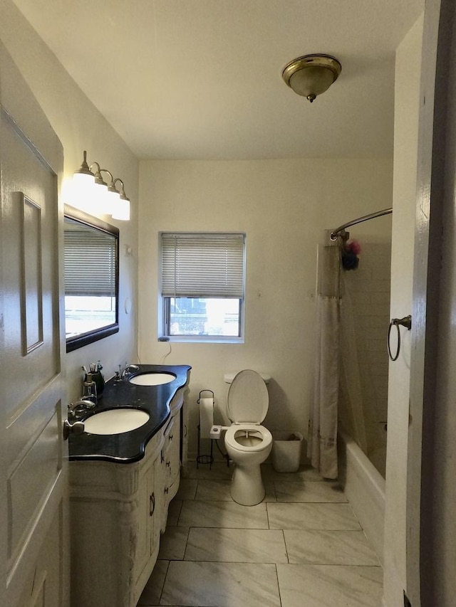 bathroom with toilet, double vanity, shower / bath combo with shower curtain, and a sink