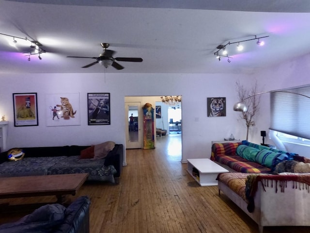 living area with a ceiling fan and wood-type flooring