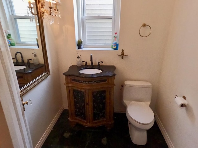 bathroom featuring toilet, baseboards, and vanity