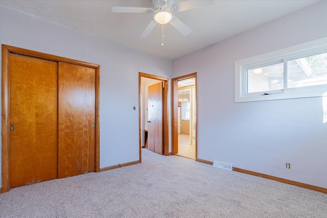 unfurnished bedroom featuring carpet flooring, a ceiling fan, visible vents, baseboards, and a closet