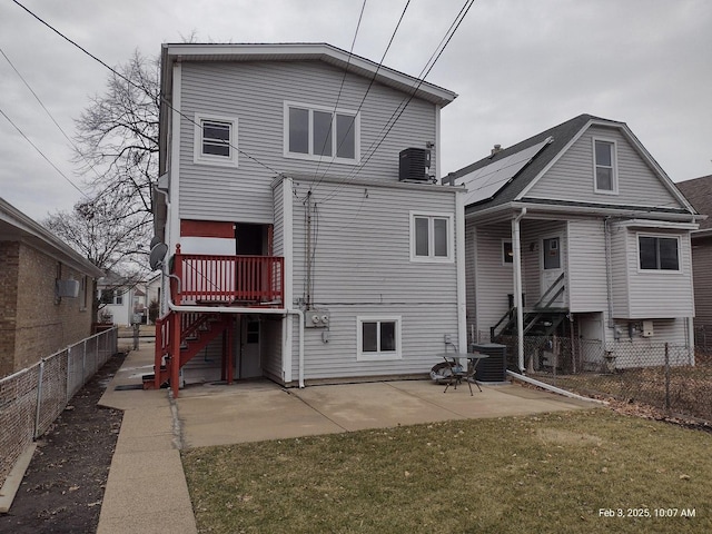 back of house with central air condition unit, a patio area, a fenced backyard, and a lawn