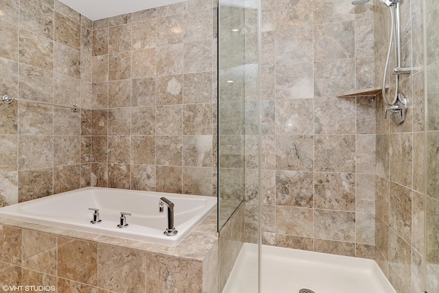 bathroom featuring a garden tub and tiled shower