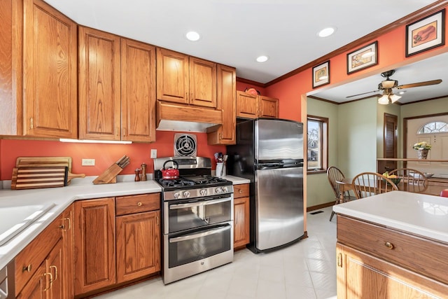 kitchen with under cabinet range hood, stainless steel appliances, and brown cabinets