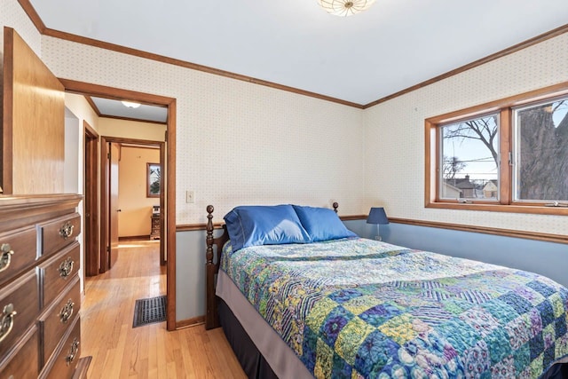 bedroom with light wood finished floors, wallpapered walls, and ornamental molding