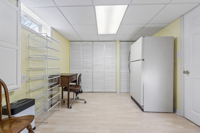 home office with a paneled ceiling and light wood finished floors