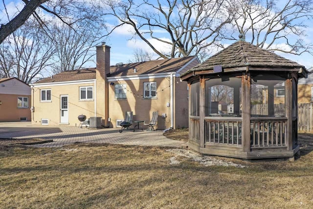 rear view of property with a gazebo, cooling unit, a chimney, a sunroom, and a patio