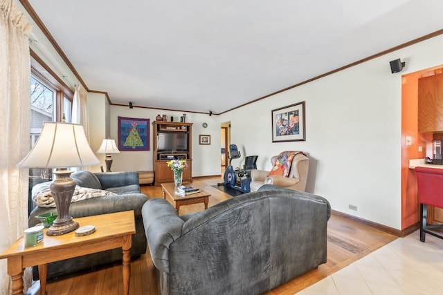 living area with baseboards, light wood finished floors, and ornamental molding