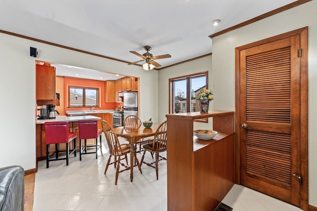 dining room with ceiling fan, baseboards, and ornamental molding