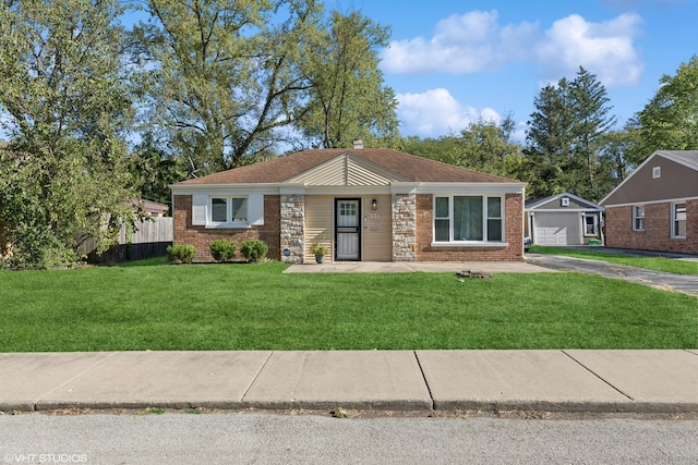 view of front of home with driveway, a chimney, fence, a front lawn, and brick siding