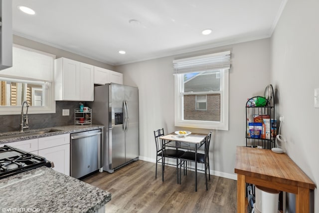 kitchen featuring stainless steel appliances, light wood-type flooring, a sink, and white cabinetry