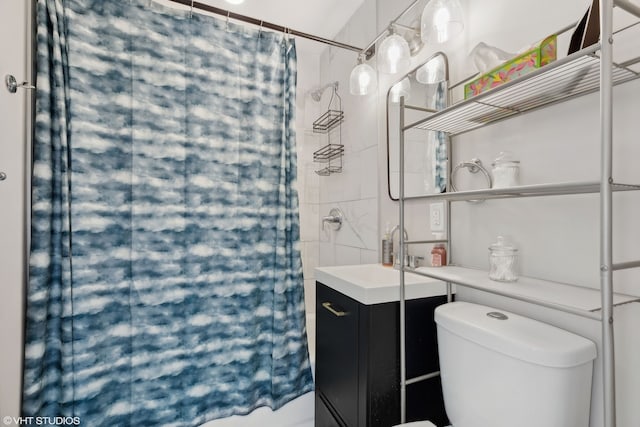 full bath featuring a shower with shower curtain, toilet, and vanity