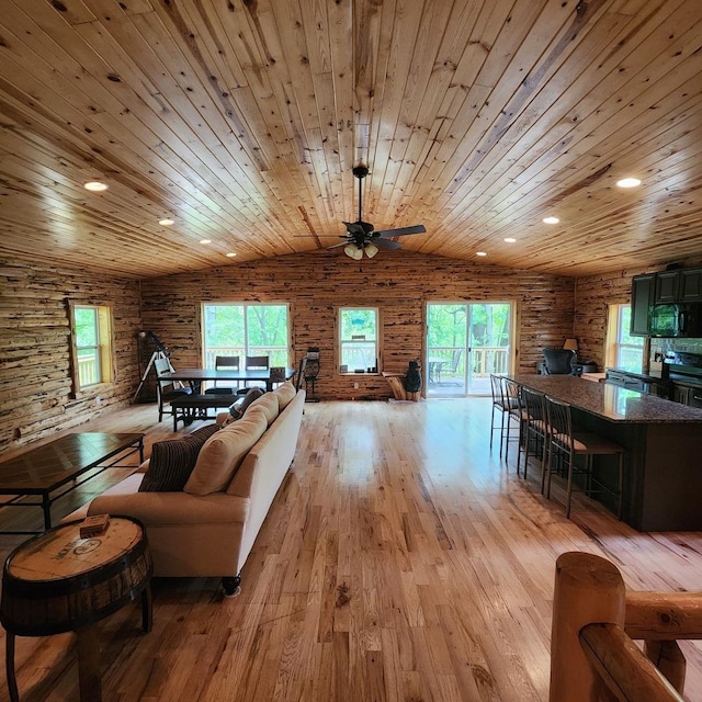 living room with a wealth of natural light, rustic walls, wood ceiling, and light wood-style floors