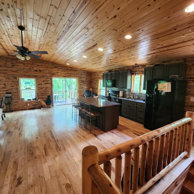 kitchen featuring a healthy amount of sunlight, black appliances, light wood-style floors, and a sink