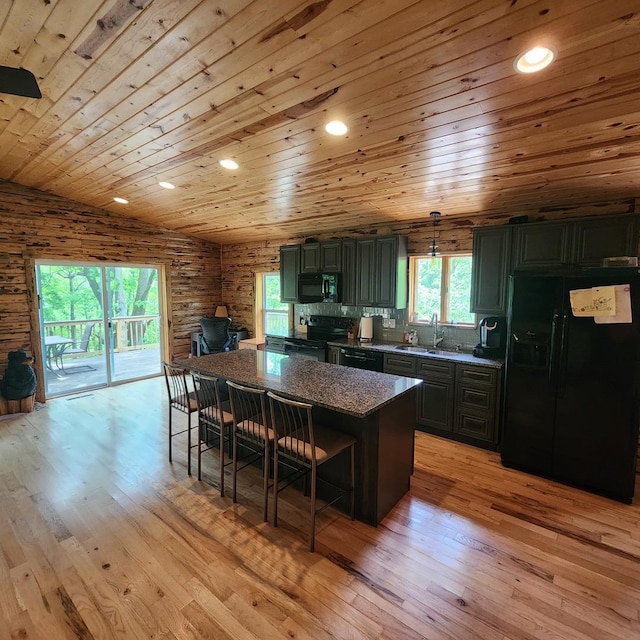 kitchen featuring light wood-style floors, wood ceiling, a sink, black appliances, and a kitchen breakfast bar