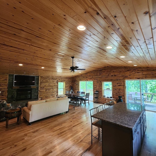 living area featuring a tile fireplace, lofted ceiling, wooden ceiling, light wood-type flooring, and recessed lighting