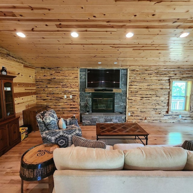 unfurnished living room with recessed lighting, wood walls, a stone fireplace, wood finished floors, and wooden ceiling