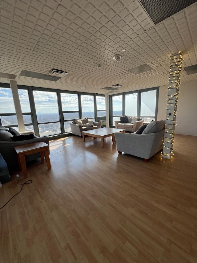 living area featuring a wall of windows, visible vents, and wood finished floors