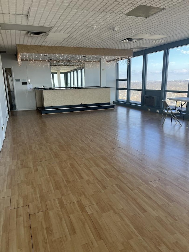 unfurnished living room with visible vents and wood finished floors