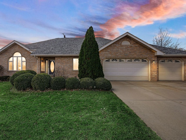 ranch-style home featuring a garage, concrete driveway, brick siding, and a lawn