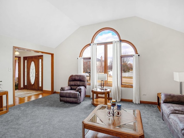 carpeted living room with lofted ceiling and baseboards