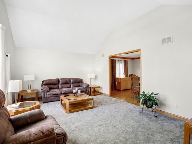 carpeted living room featuring high vaulted ceiling, visible vents, and baseboards