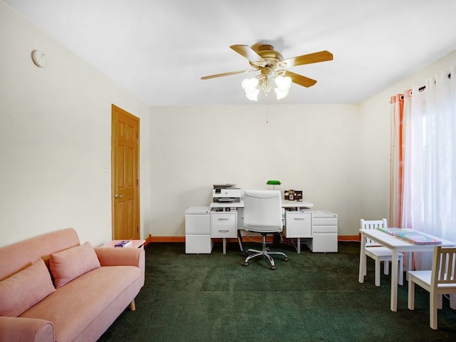 office with a ceiling fan, dark carpet, and baseboards