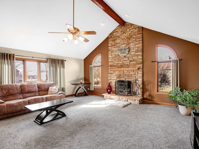 carpeted living room with a large fireplace, baseboards, ceiling fan, high vaulted ceiling, and beam ceiling