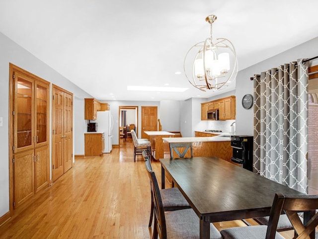 dining space with light wood-style flooring, a chandelier, and recessed lighting