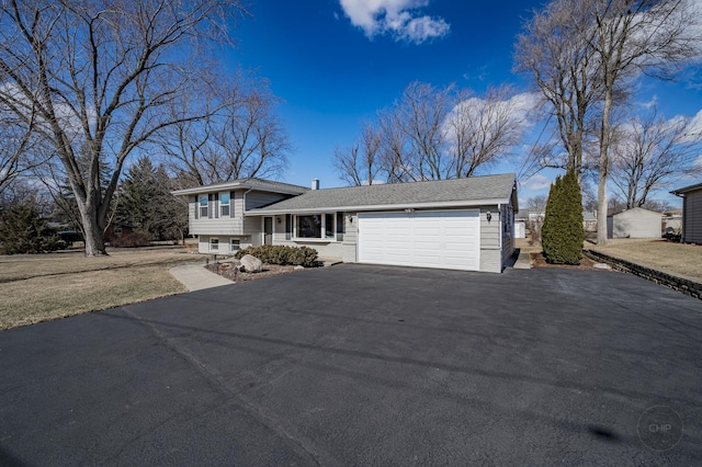 split level home with a garage and aphalt driveway