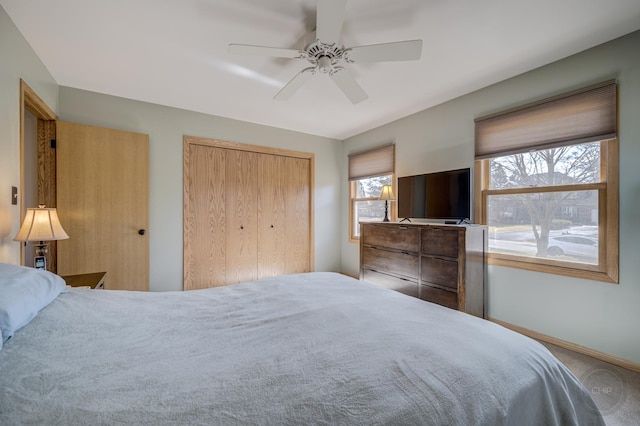 bedroom featuring a ceiling fan, a closet, and baseboards