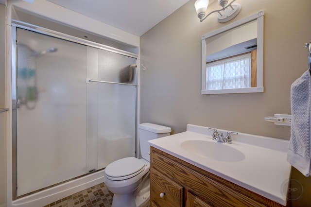 bathroom featuring a stall shower, vanity, and toilet