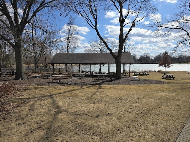 view of property's community with a gazebo, a water view, and fence