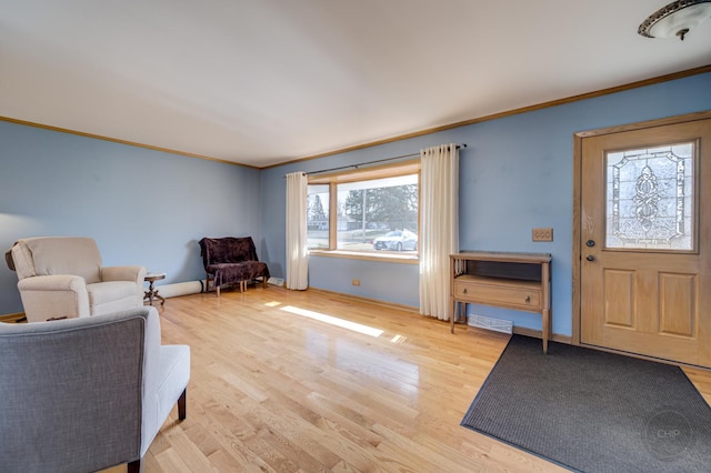 interior space featuring baseboards, crown molding, and light wood finished floors