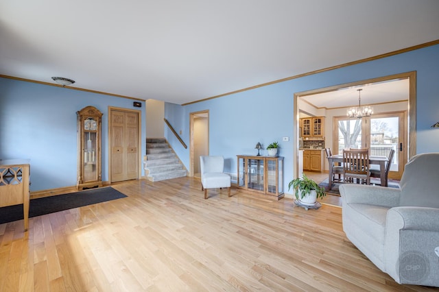 interior space featuring light wood-style floors, a chandelier, ornamental molding, and stairway