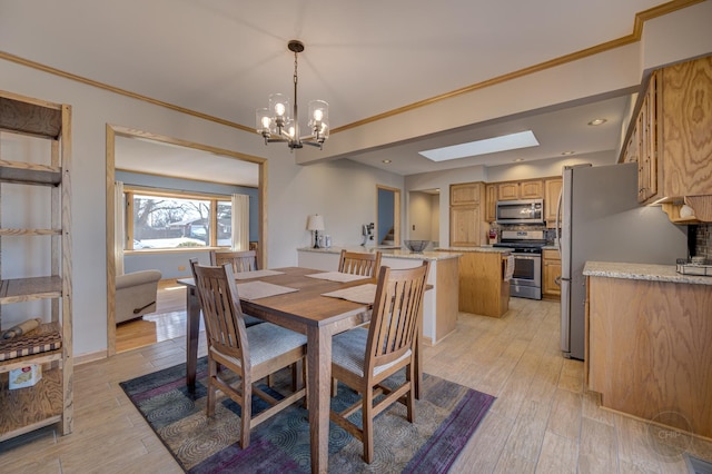 dining space with ornamental molding, a skylight, light wood-style flooring, and a notable chandelier