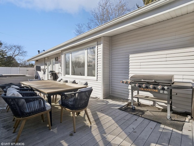 wooden deck with grilling area, outdoor dining area, and fence