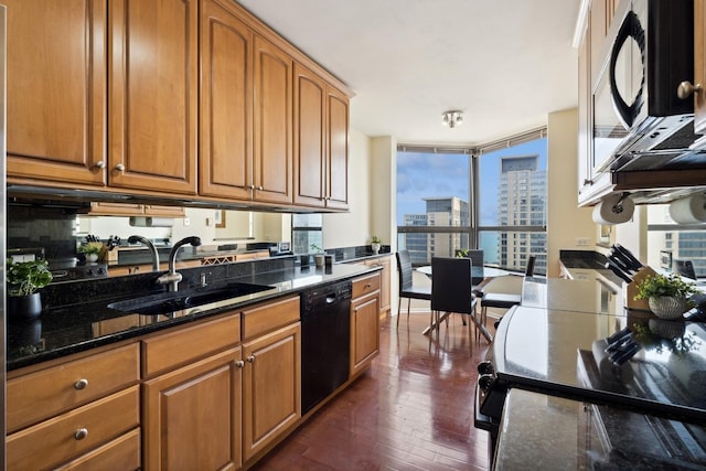 kitchen featuring black appliances, brown cabinetry, and a sink