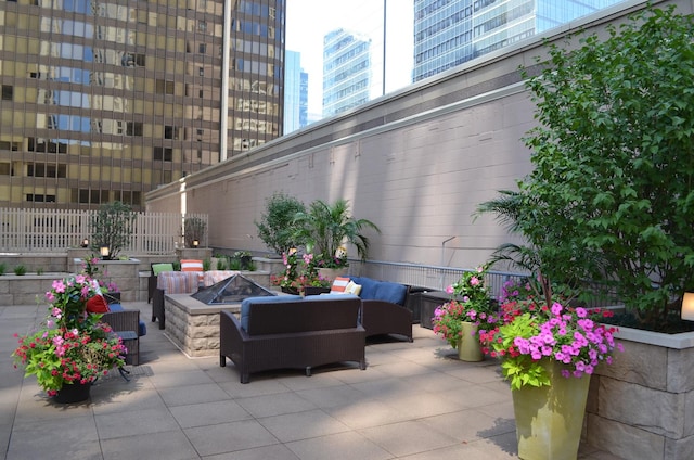 view of patio / terrace featuring a view of city and an outdoor living space with a fire pit