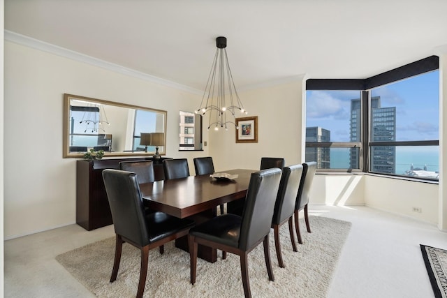 carpeted dining area featuring a chandelier, a city view, baseboards, and crown molding