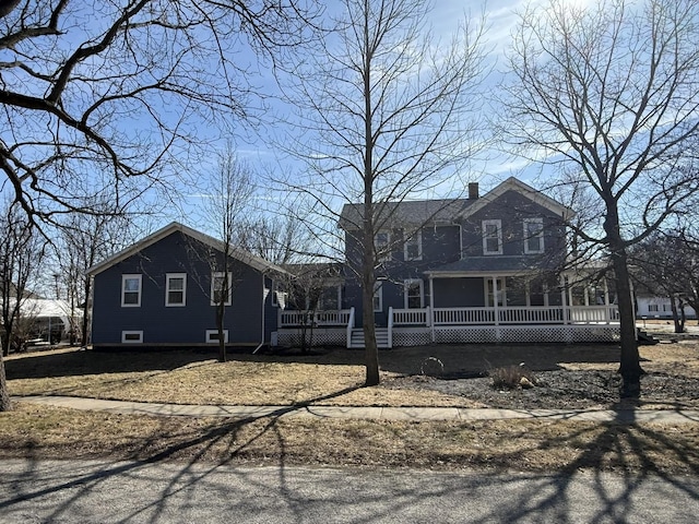 view of front of house with covered porch and a chimney