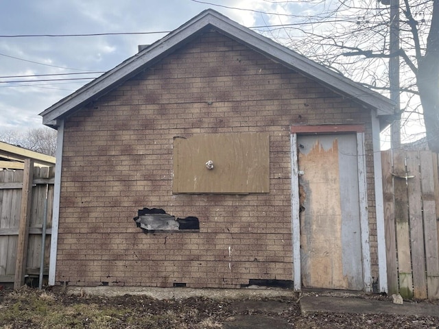 view of home's exterior featuring brick siding and fence