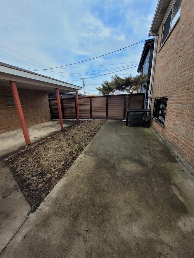 view of yard with a patio, central AC unit, and fence