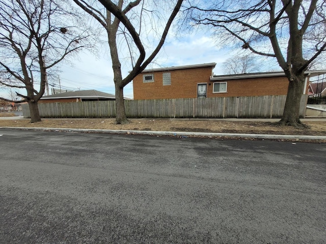 view of property exterior with a fenced front yard and brick siding