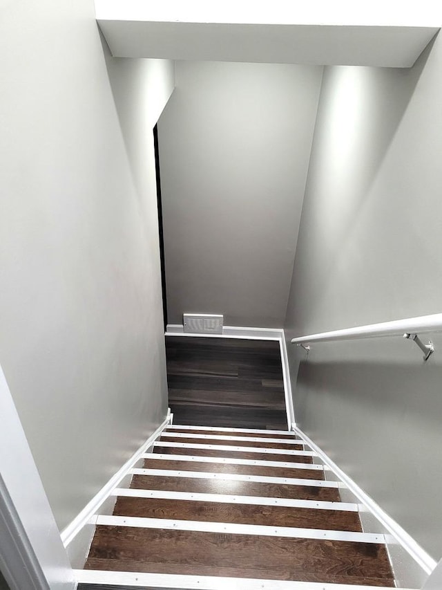 stairway with baseboards and wood finished floors