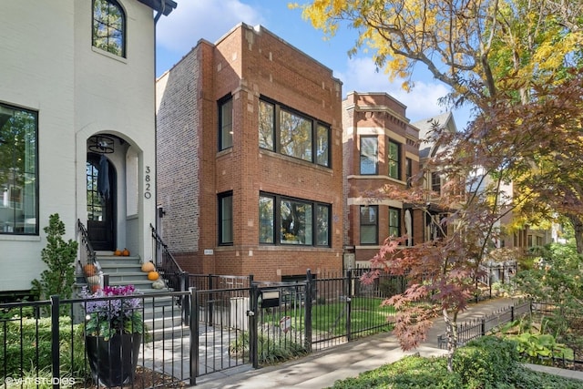 view of front facade with brick siding and a fenced front yard