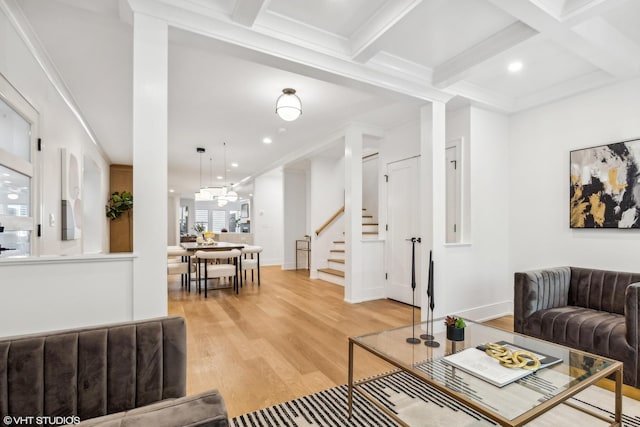 living area with beam ceiling, coffered ceiling, light wood-type flooring, and stairs