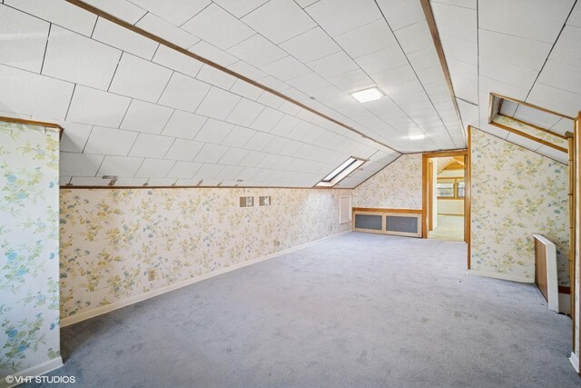 bonus room with vaulted ceiling, carpet, baseboards, and wallpapered walls