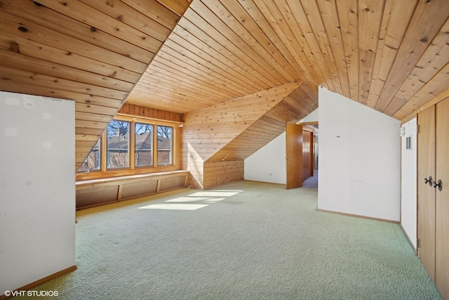 additional living space featuring vaulted ceiling, wood walls, wooden ceiling, and carpet flooring